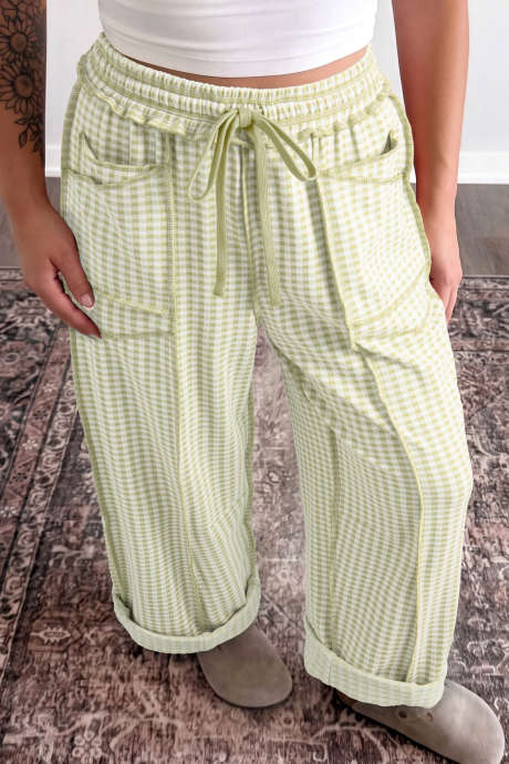 Calça de corte reto com detalhes contrastantes em xadrez verde, cordão e cintura elástica.