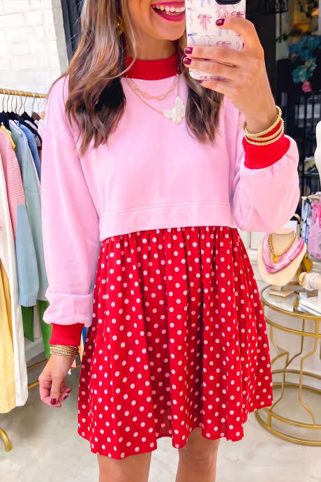 Vestido curto plissado com corpete de mangas compridas em blocos de cor rosa e estampa de bolinhas contrastantes.