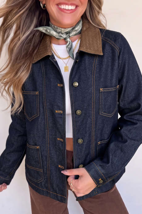 Jaqueta jeans azul marinho com gola contrastante, detalhes de costura e botões.
