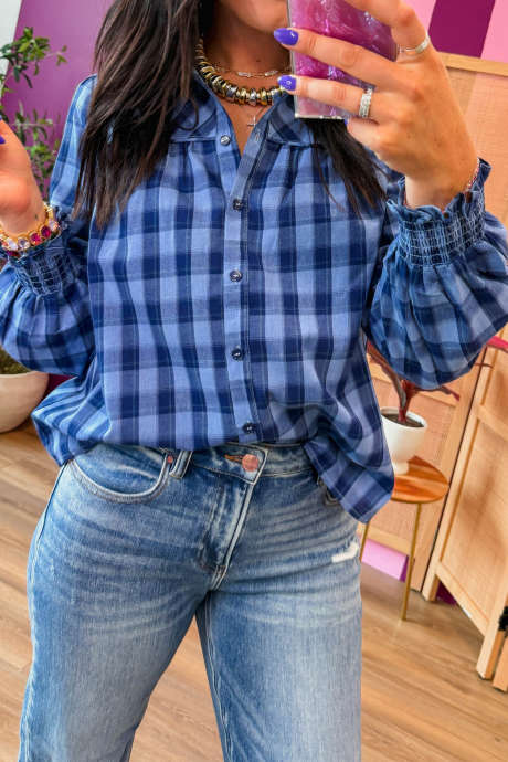 Camicia a maniche lunghe a quadri blu con polsini arricciati e volant.