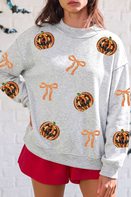 Moletom de Halloween com estampa de abóbora com laço e lantejoulas cinza claro e costura aparente.