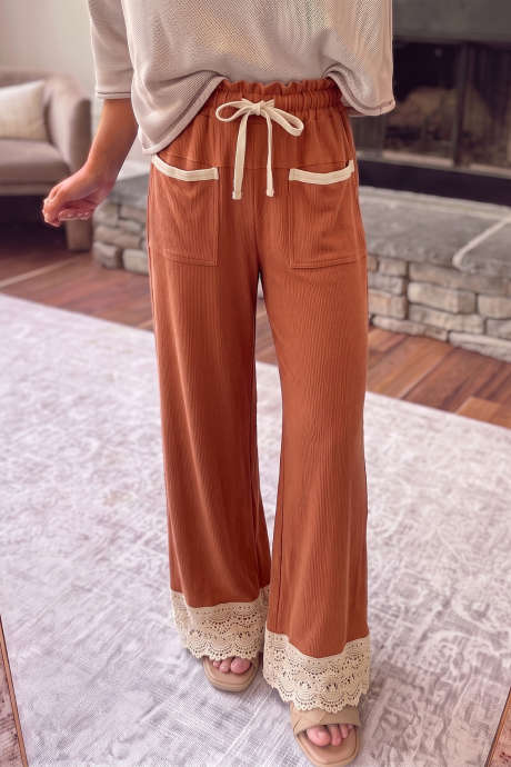 Calça canelada de perna larga com detalhes em renda e cintura alta, com cordão ajustável.