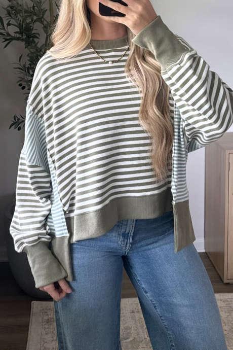 Top casual in maglia a righe verdi con spalle scese e orlo asimmetrico.