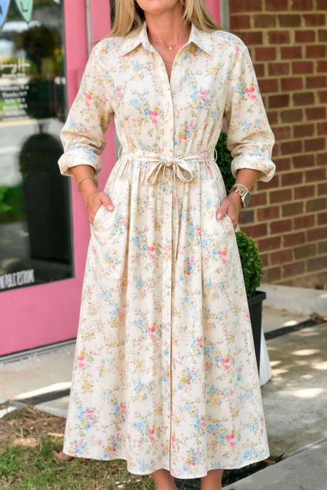 Abito midi beige con stampa floreale, colletto a camicia, abbottonatura frontale e cintura in vita.