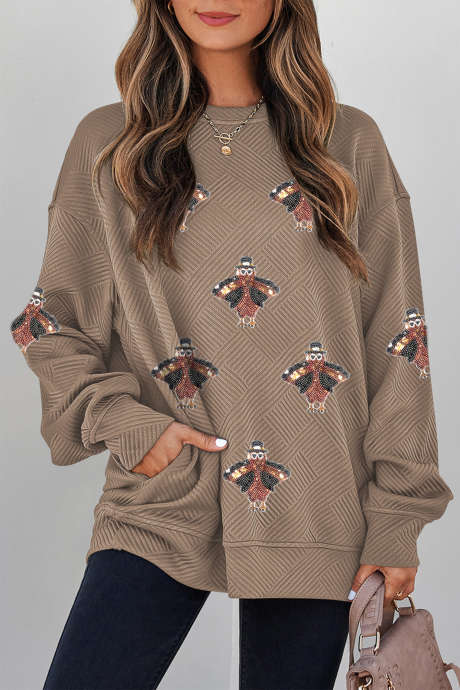 Trendy, getextureerde trui met pailletten en een kalkoenprint in perkamentkleur. Casual sweatshirt.