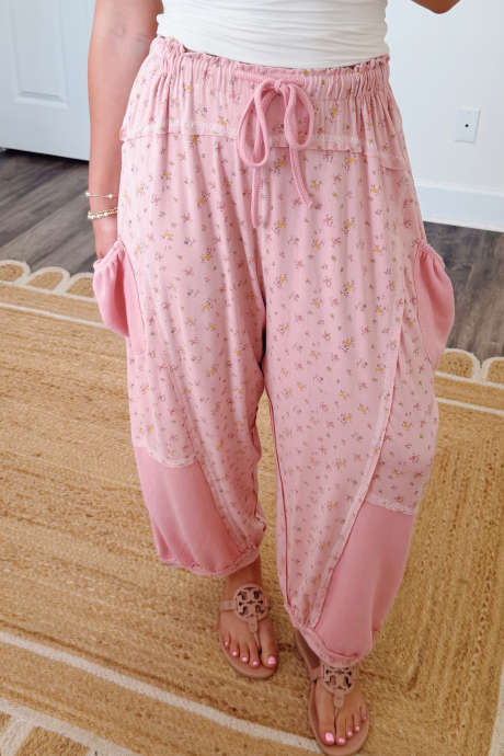 Pantalones casuales con estampado floral rosa, bloques de color, costuras expuestas y patchwork en los bolsillos.
