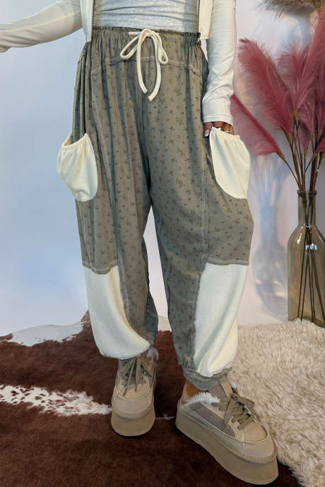 Pantalones casuales con estampado floral gris, bloques de color, costuras expuestas y patchwork en los bolsillos.