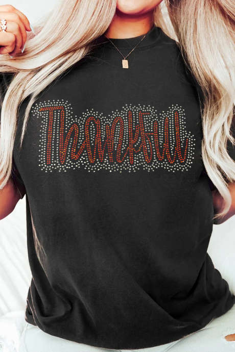 Camiseta informal negra de cuello redondo con pedrería y diseño de agradecimiento.
