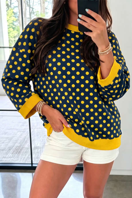 Top de cuello redondo con mangas tres cuartos, estampado de lunares azules y ribete en contraste.